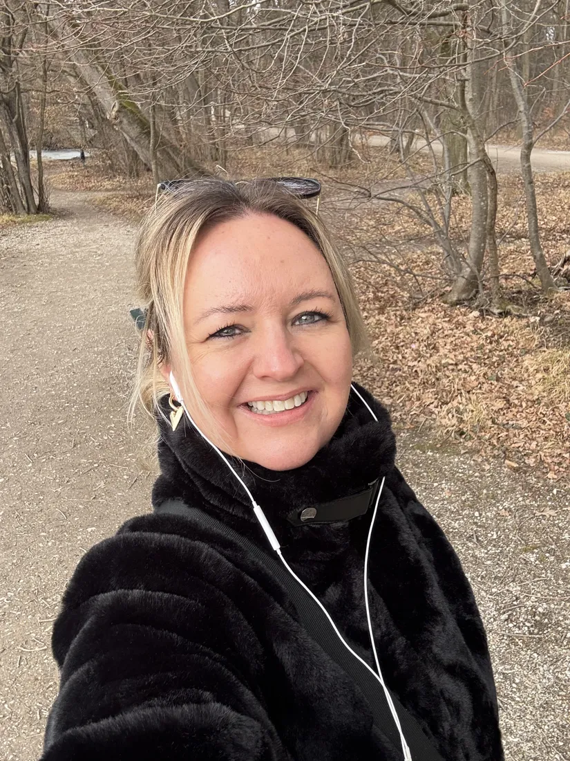 Anke lächelnd auf einem Herbstweg im Wald